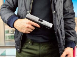 torso of a man holding a gun