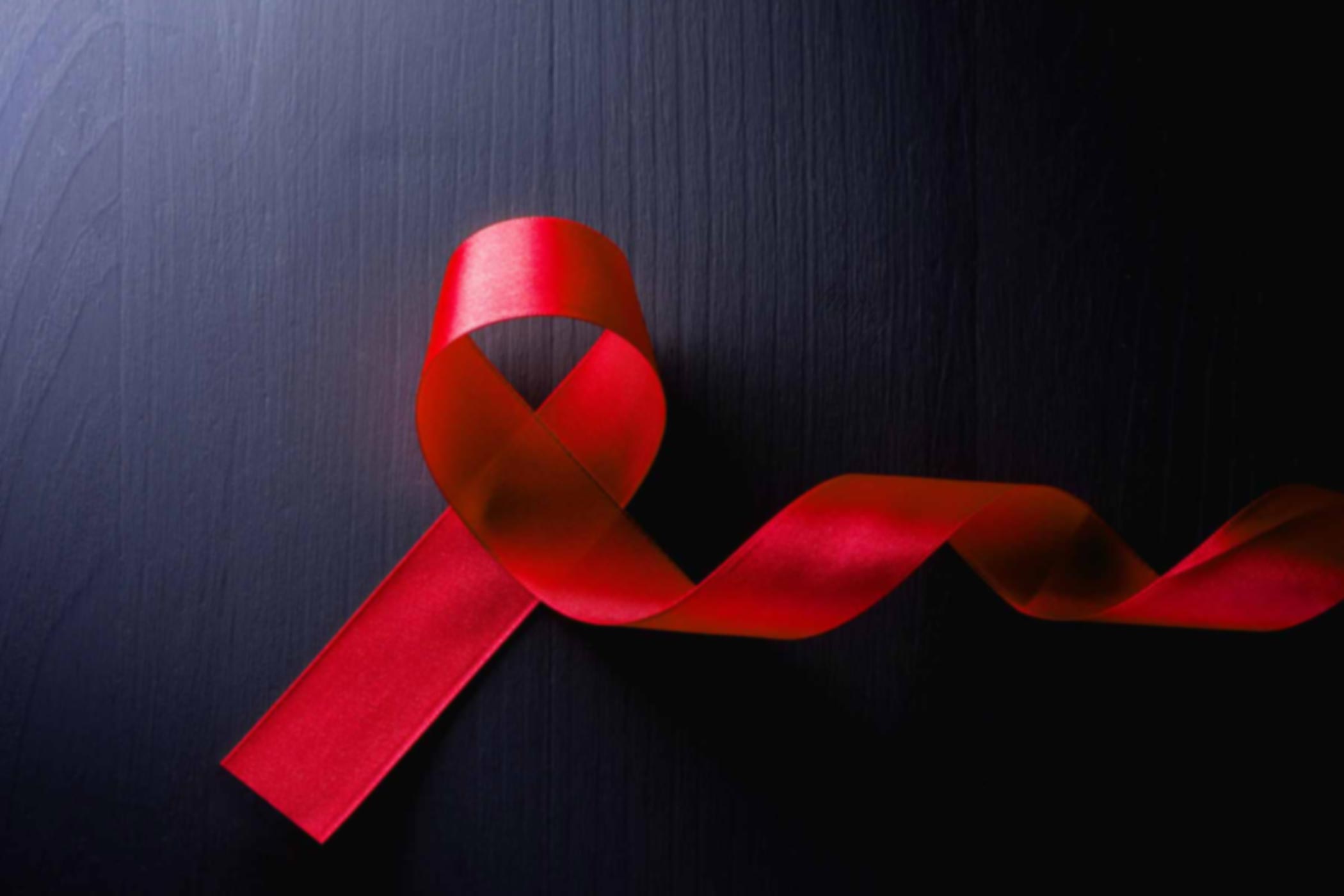 An-Overview-of-HIV-&-AIDS AIDS red ribbon on a dark background