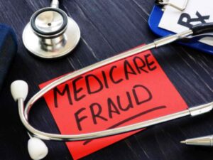 stethoscope and re note written Medicare Fraud on desk