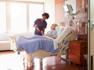 nurse showing a guide to a patient in hospital bed