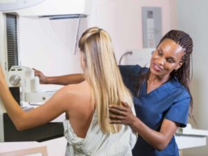 nurse helping patient doing a mammogram